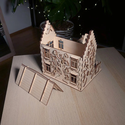 High angle view showing a removable roof panel next to the main body of an engraved laser cut plywood family dollhouse.