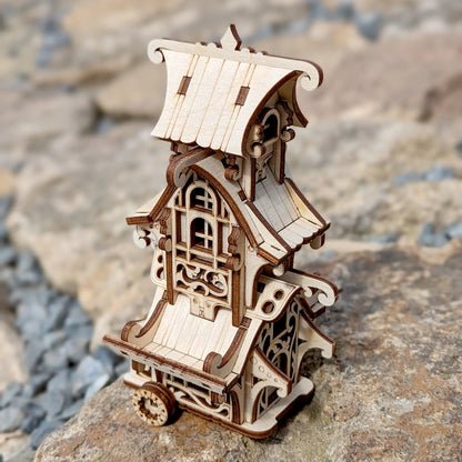 Miniature fantasy caravan wagon made of laser cut plywood with detailed stairs and flower box on a white background.
