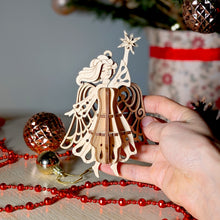 Load image into Gallery viewer, Laser-cut angel ornament with intricate wings and a star for holiday decor
