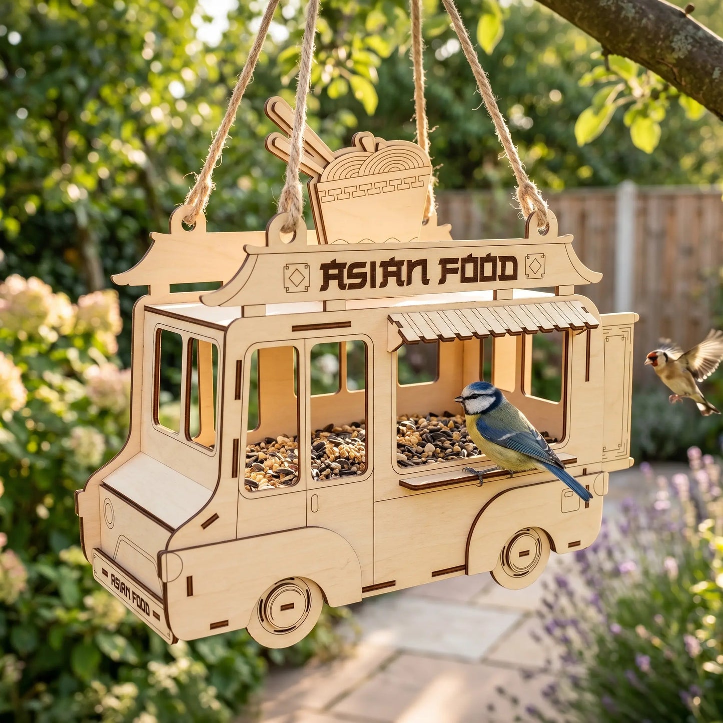 Wooden bird feeder shaped like an Asian food truck with a bird perched on it, hanging outdoors.
