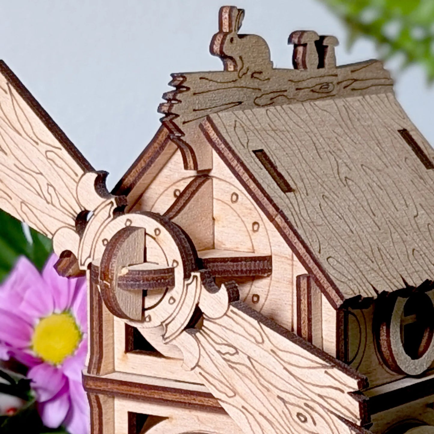 Detailed macro photo of a laser cut plywood roof ridge line showcasing a tiny engraved rabbit and cute forest mushrooms.