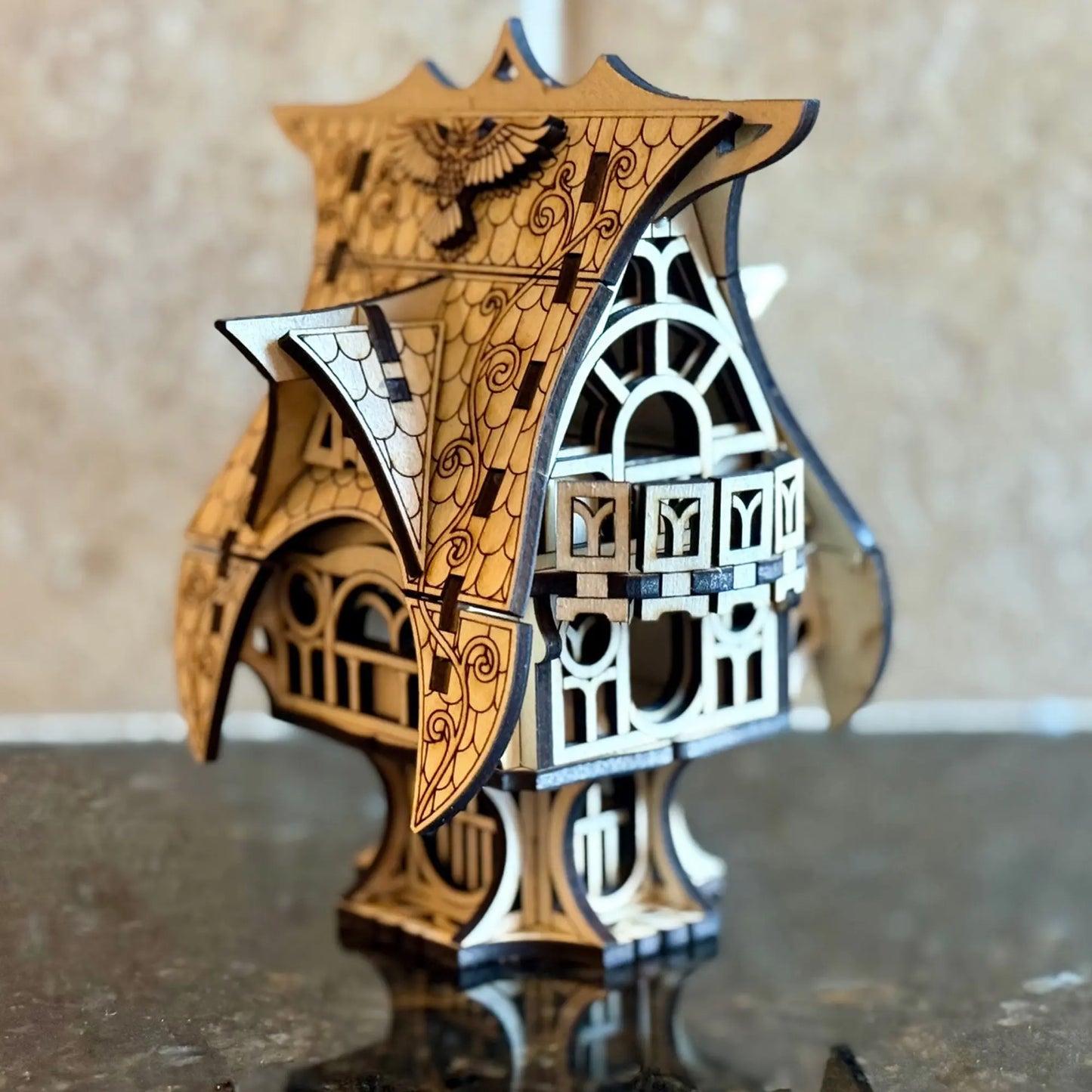 A beautiful perspective side view of a whimsical miniature fairytale house ornament, from multilayered laser cut plywood.