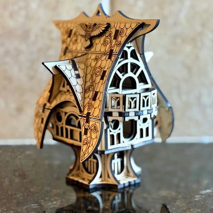 A beautiful perspective side view of a whimsical miniature fairytale house ornament, from multilayered laser cut plywood.