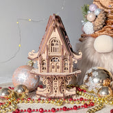Wooden laser ct model of a house with Christmas elf house decorations on a gray background