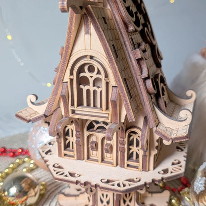 Close up view of a laser cut plywood elf cottage facade showcasing miniature arched windows, doors, and balconies.