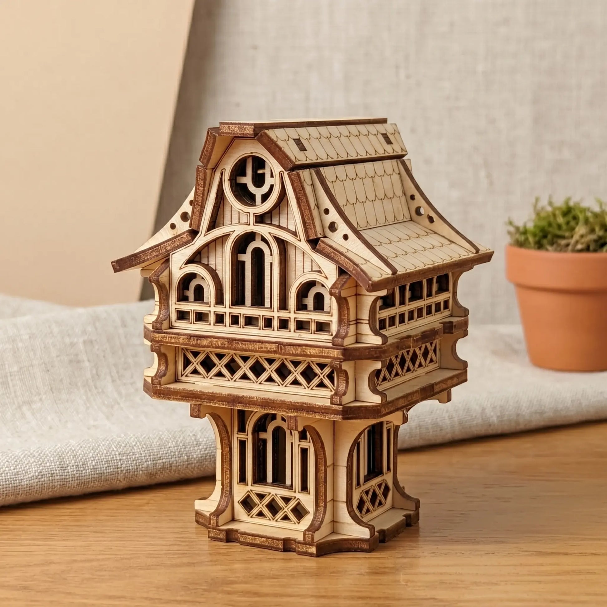 Wooden model of a fairy house on a wooden surface with a neutral background