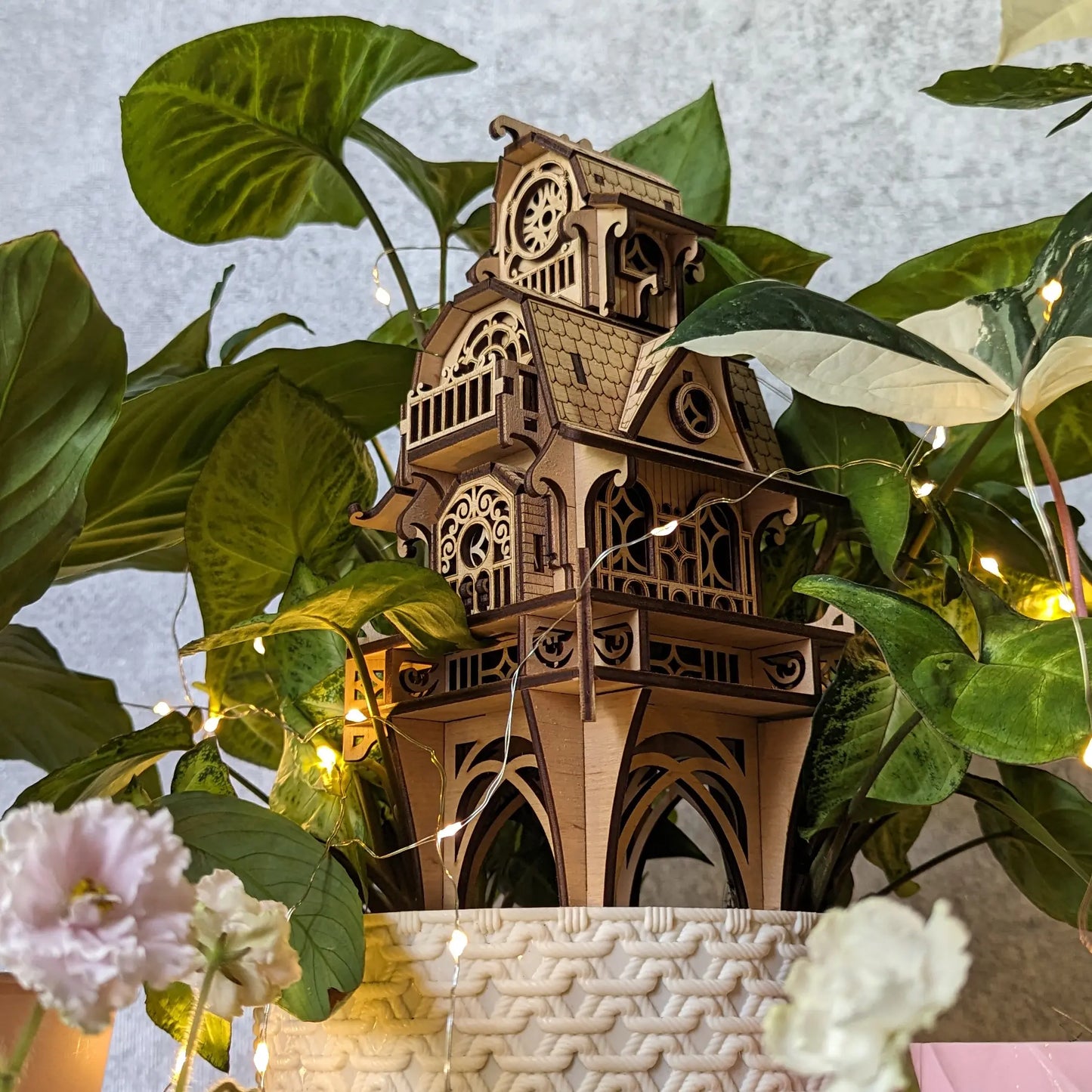 Multi-tier fairy castle stake placed in a potted plant, crafted from beautiful natural laser cut plywood layers.