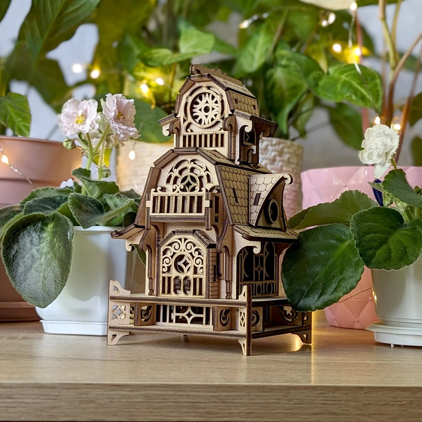 Three-quarter eye-level view of the finished miniature witch cottage, crafted from natural laser cut plywood core.