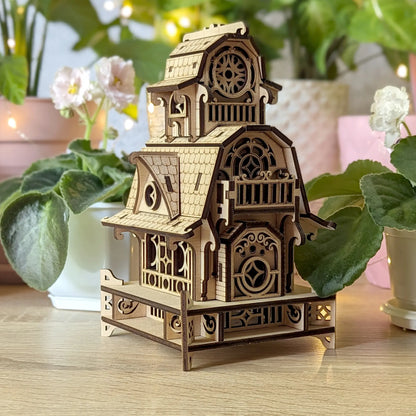 Side-angle shot of the miniature fantasy cottage prototype, highlighting the modular laser cut plywood assembly.