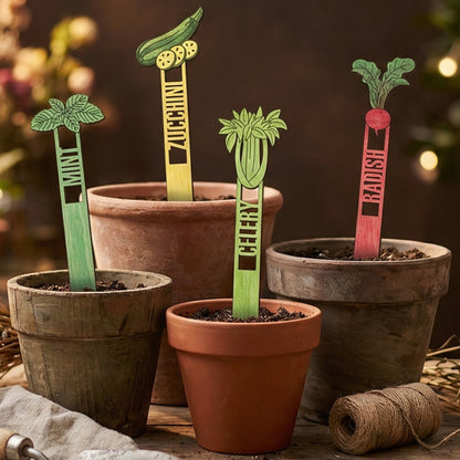Set of wooden laser cut Garden Stakes 2 with colorful designs for mint, zucchini, celery, and radish featuring engraved name labels on stakes, placed in terracotta pots against a warm bokeh-lit background.