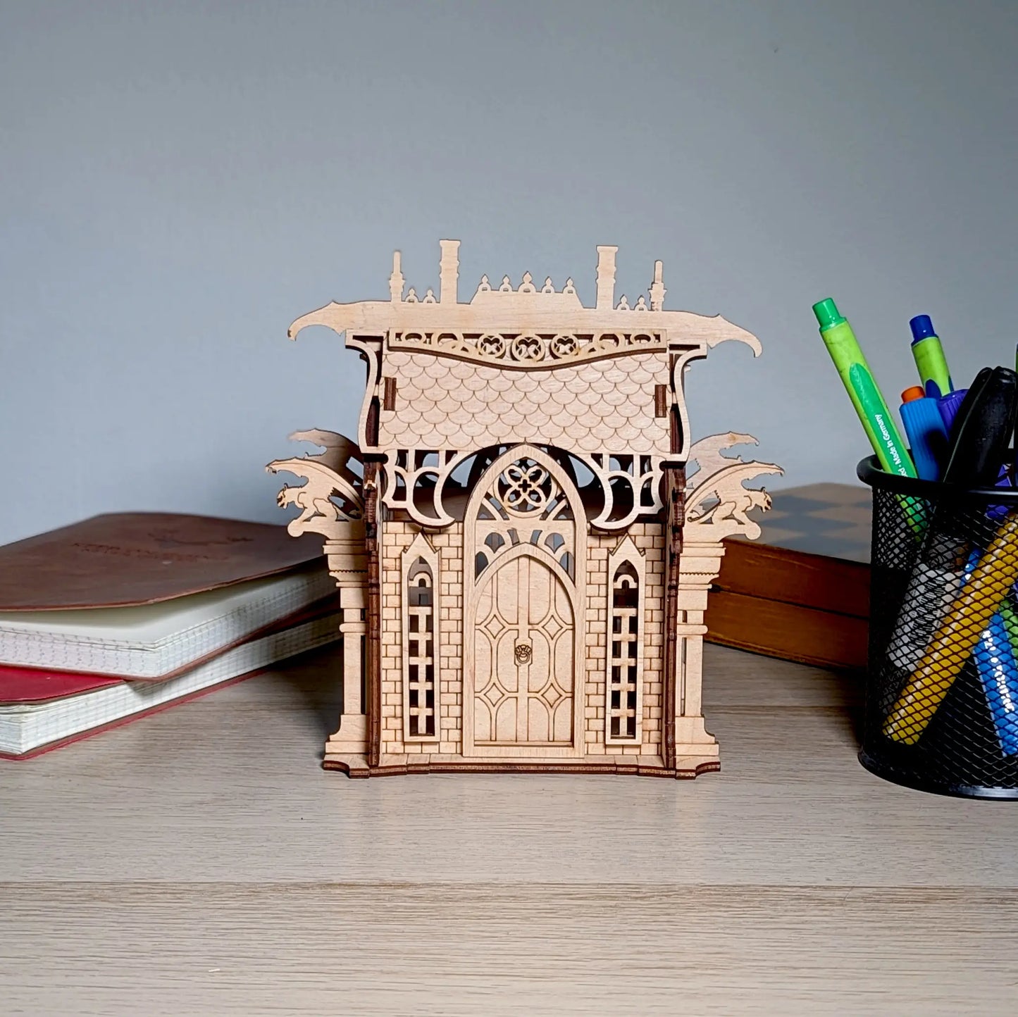 A straight front eye-level view of a decorative gothic building box organizer crafted beautifully from laser cut plywood