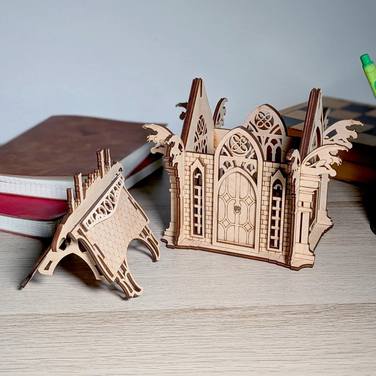 A product photo of an assembled gothic crypt box with its roof detached on a table, crafted from fine laser cut plywood.