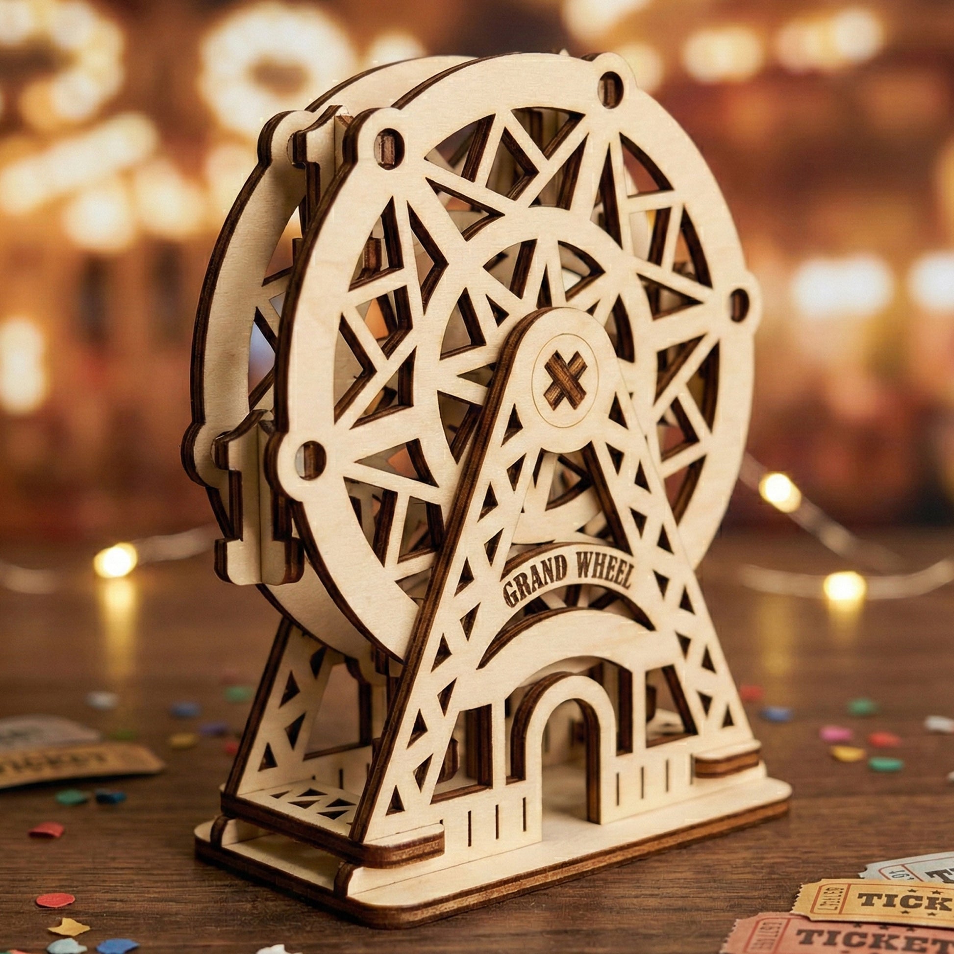 Angled perspective of a laser cut plywood Ferris wheel, showing its double-layered wheel construction and interlocking support beams. The natural wood grain is highlighted against a backdrop of warm, bokeh carnival lights and confetti.