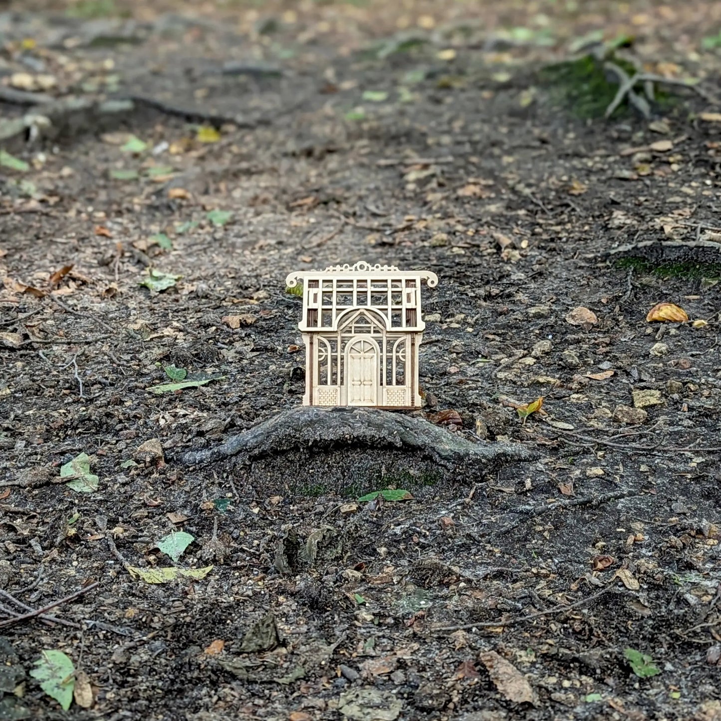 A cozy straight front perspective view of a miniature holiday village greenhouse toy built entirely of laser cut plywood