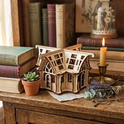 Wooden laser cut model of a house on a wooden surface with books and decorative items.