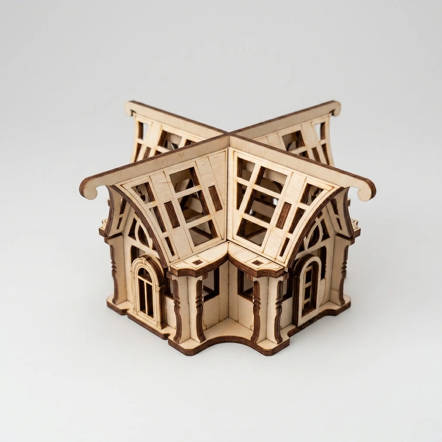 Wooden laser cut greenhouse model on a white background