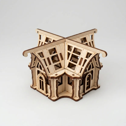 Wooden laser cut greenhouse model on a white background