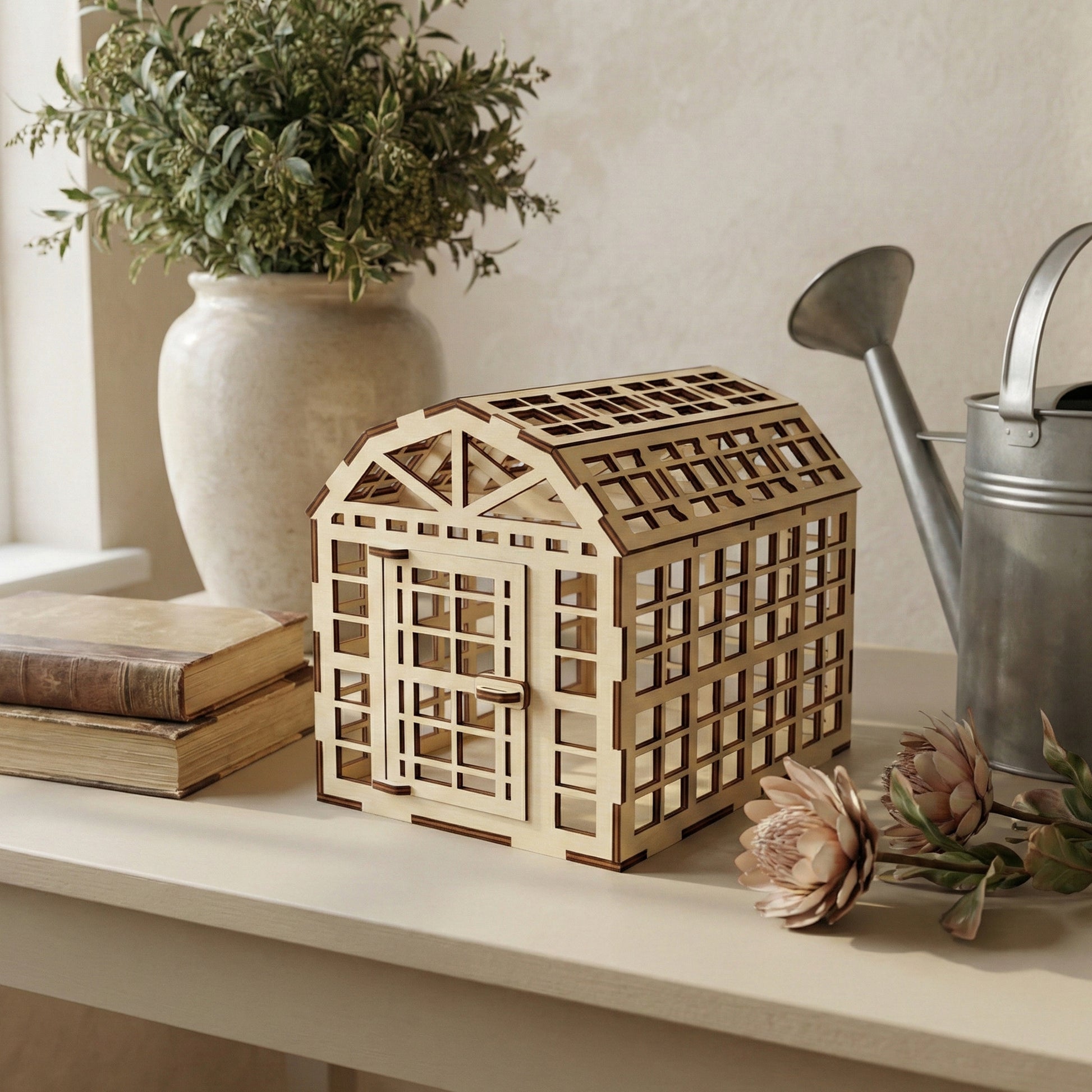 Rustic laser cut wooden greenhouse model with grid-patterned walls, hinged door, and layered roof shingles, displayed against a gentle blurred indoor background.