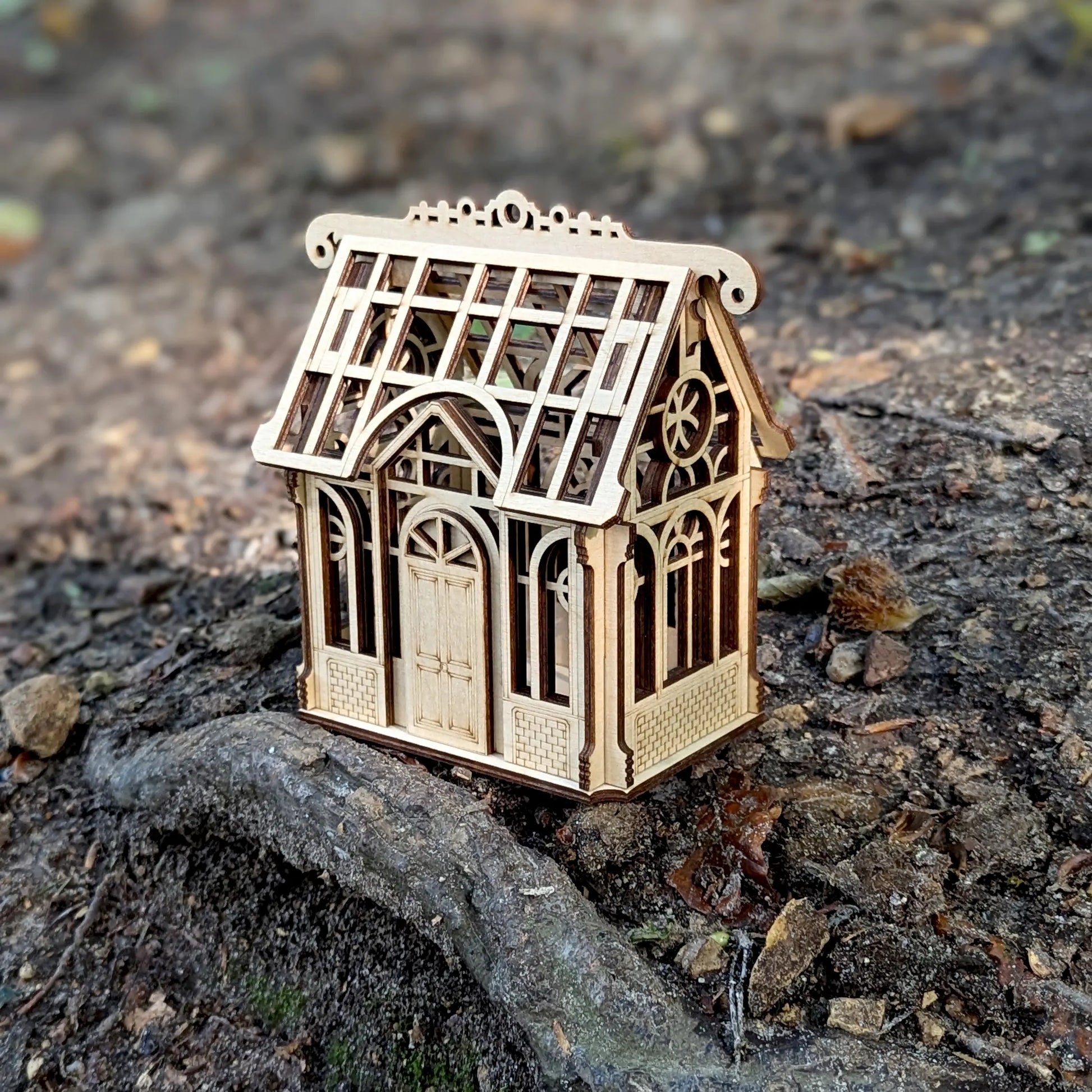 Detailed  product photo focusing on a tiny engraved shamrock clover on the side of a laser cut plywood house.