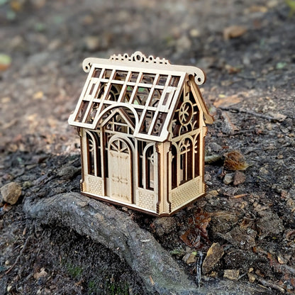 Detailed  product photo focusing on a tiny engraved shamrock clover on the side of a laser cut plywood house.