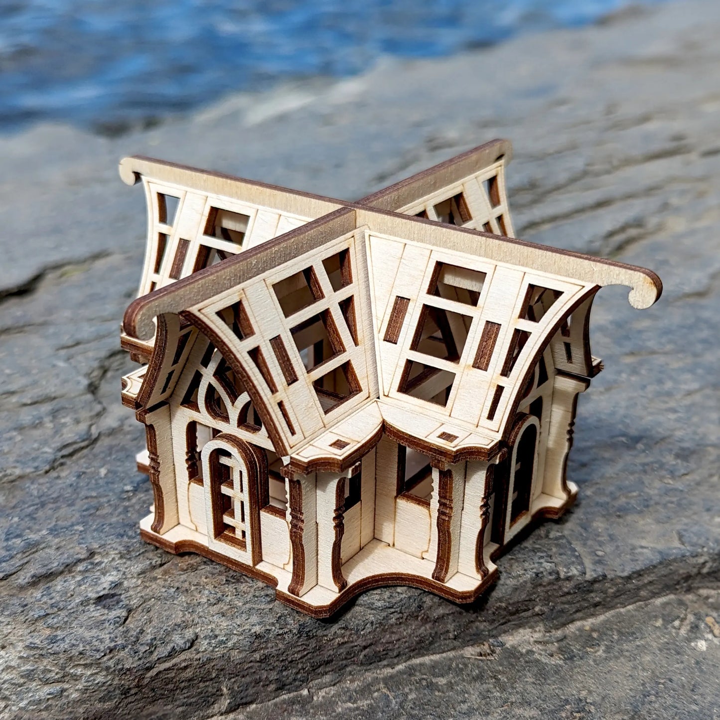 Three-quarter high-angle shot of a decorative botanical house model kit manufactured from flat laser cut plywood.