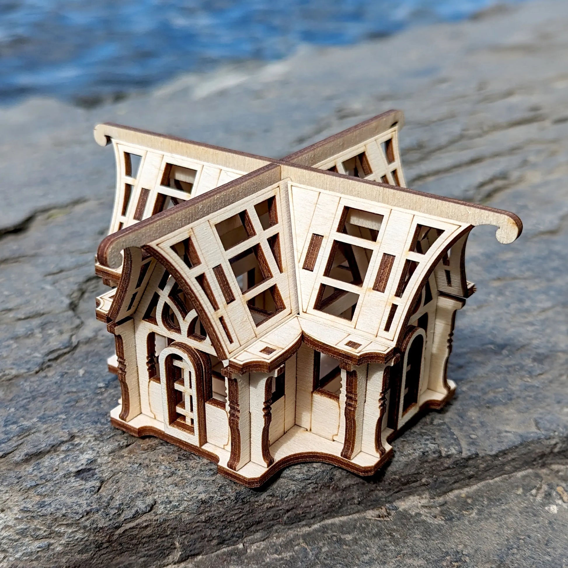 Three-quarter high-angle shot of a decorative botanical house model kit manufactured from flat laser cut plywood.