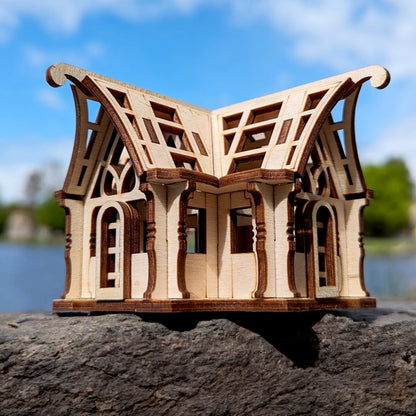 Close eye-level profile of a mini wooden greenhouse made of laser cut plywood, showcasing ornate gothic arch windows.