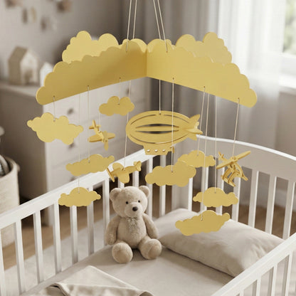 Natural beige laser cut wooden hanging toy with cloud clusters, propeller planes, and a dirigible, crafted as a crib mobile for nurseries.