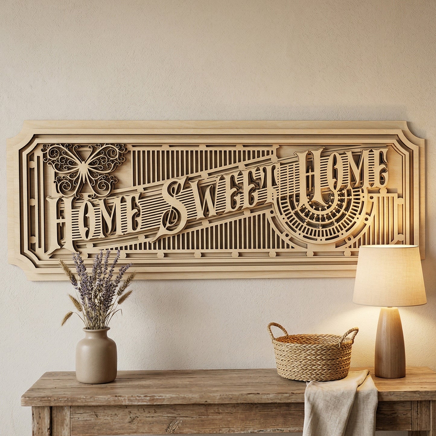 A large, multi-layered 3D "Home Sweet Home" sign handcrafted from laser-cut plywood. The intricate design features an Art Deco aesthetic with geometric lattices, a decorative butterfly icon, and stacked wood panels. Displayed on a neutral wall above a rustic entryway table with a warm lamp and lavender.