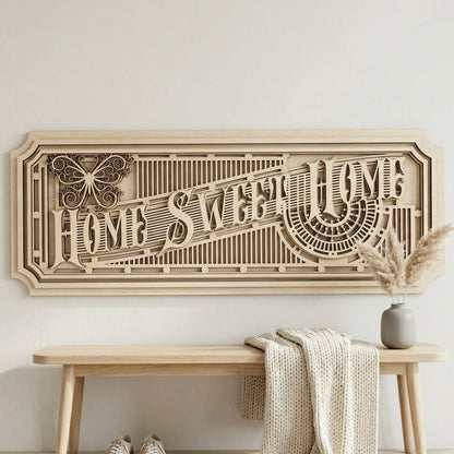 Frontal view of an architectural 3D "Home Sweet Home" wall art piece made from layered light-colored plywood. The horizontal sign showcases precise laser-cut details, including a stylized butterfly and sunburst patterns. Styled in a minimalist entryway above a light wood bench with a cozy knitted throw.