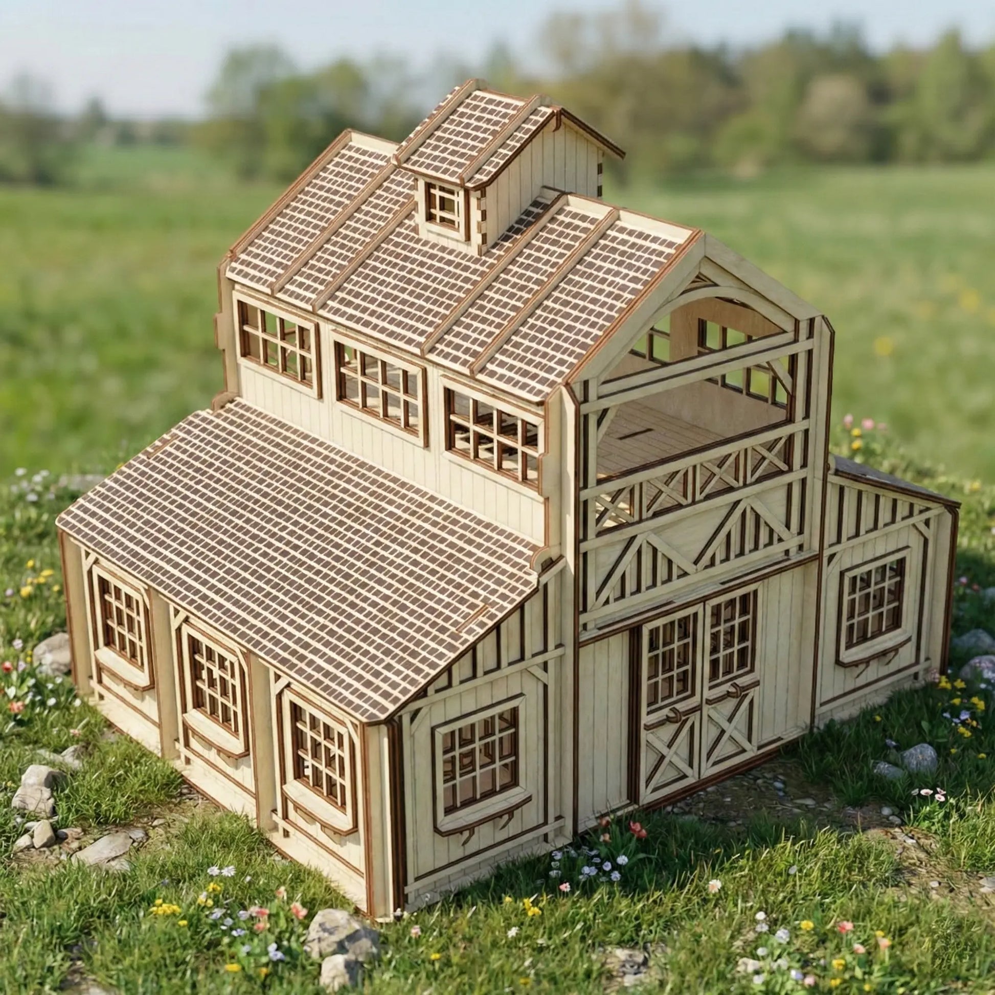 High angle view of an assembled laser cut plywood horse stable barn model resting outdoors in a lush green grass field.