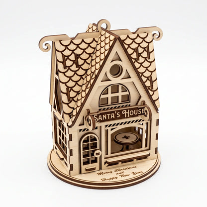 Side perspective of laser cut plywood Santa house model with engraved roof and stand on white backdrop.