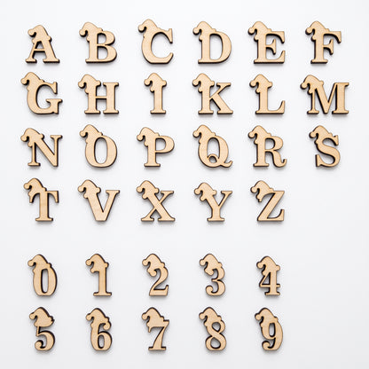 Full alphabet set and numbers 0 to 9 in laser cut plywood with engraved Santa hats, flat lay on white backdrop