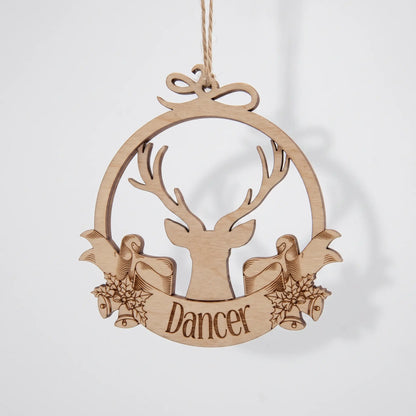 Front view of hanging laser cut plywood Dancer reindeer bauble ornament with engraved ribbon on plain white backdrop.