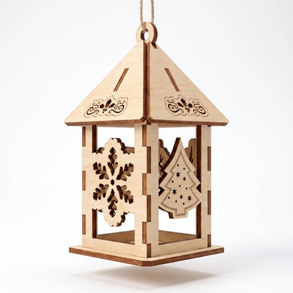 Laser cut plywood holiday lantern ornament featuring snowflake and Christmas tree panels, isolated on plain white