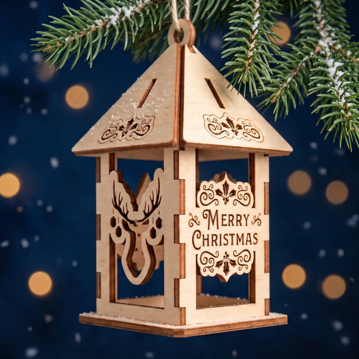 Laser cut plywood lantern ornament with deer cutout and Merry Christmas sign hanging on festive evergreen branch.
