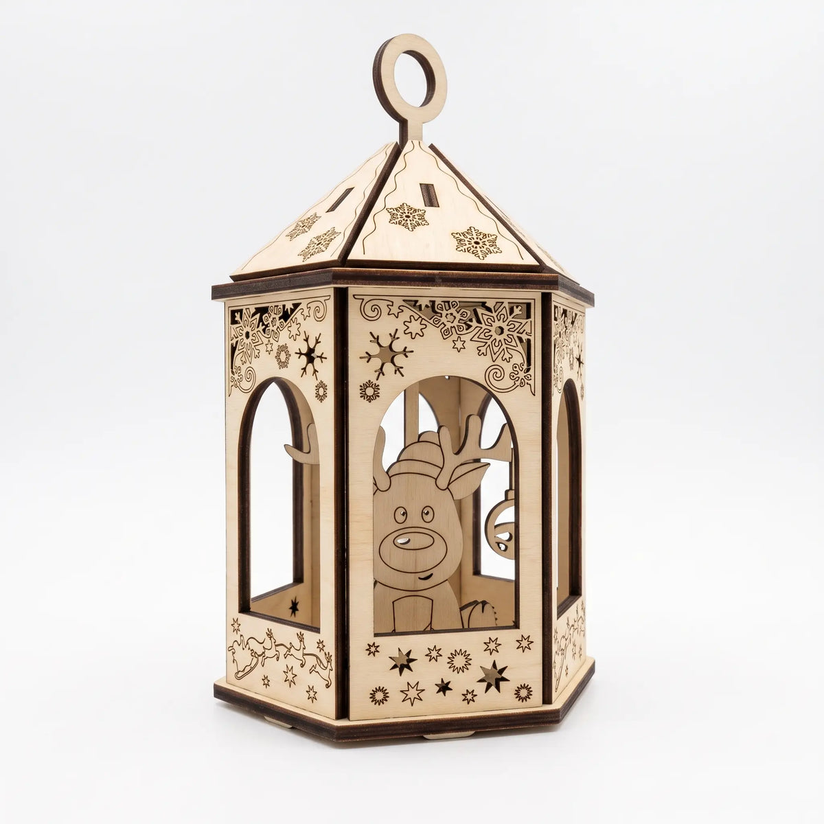 Three-quarter view of laser cut plywood lantern ornament featuring reindeer silhouette and snowflakes on white.
