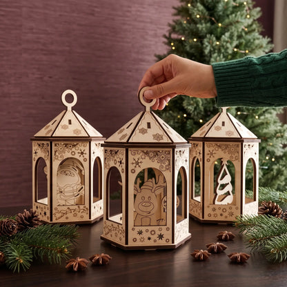 Hand lifts laser cut plywood reindeer lantern beside matching ornaments on dark table in front of holiday tree