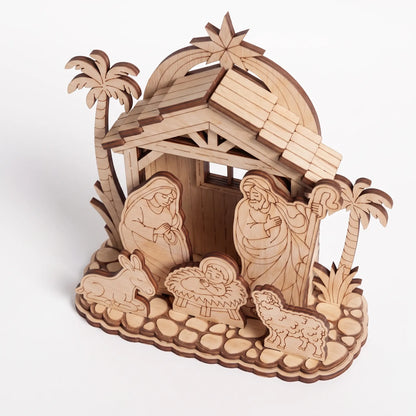 High angle view of layered laser cut plywood nativity scene with cobblestone base and stable on white background.