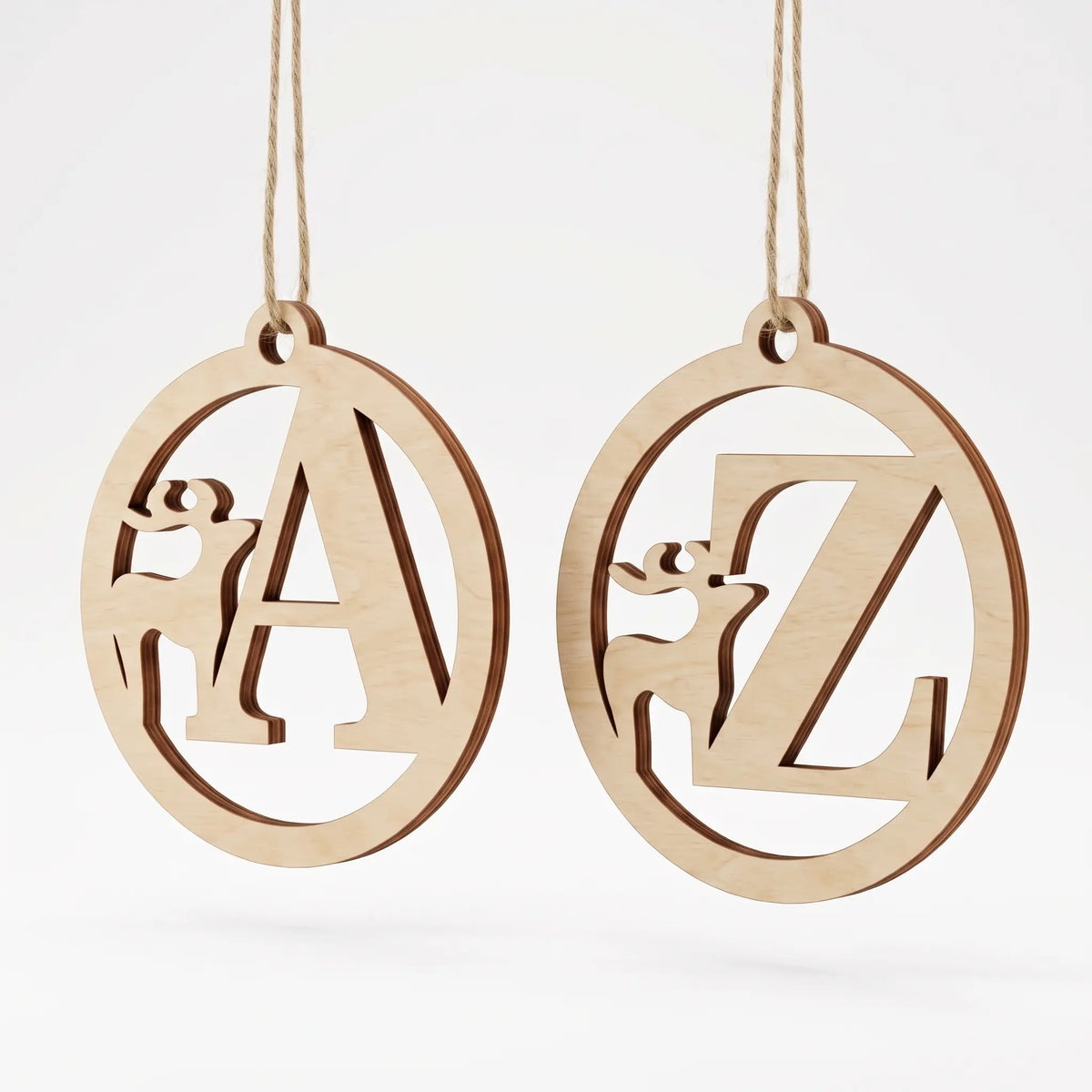 Two laser cut plywood holiday tree baubles featuring deer silhouettes and monogram letters A and Z on plain white.