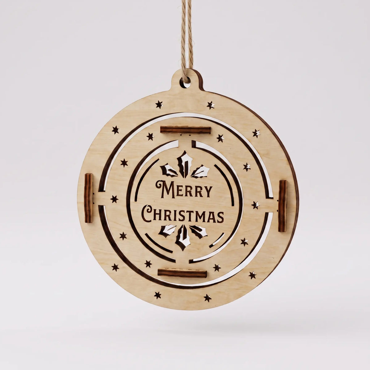 Front view of flat laser cut plywood bauble with Merry Christmas lettering and stars suspended against plain white