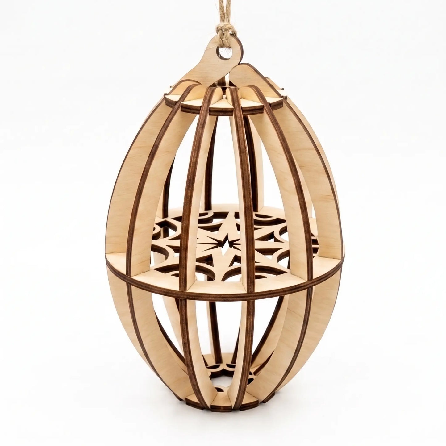 Assembled 3D oval laser cut plywood Christmas bauble ornament with internal snowflake disc, on white background.