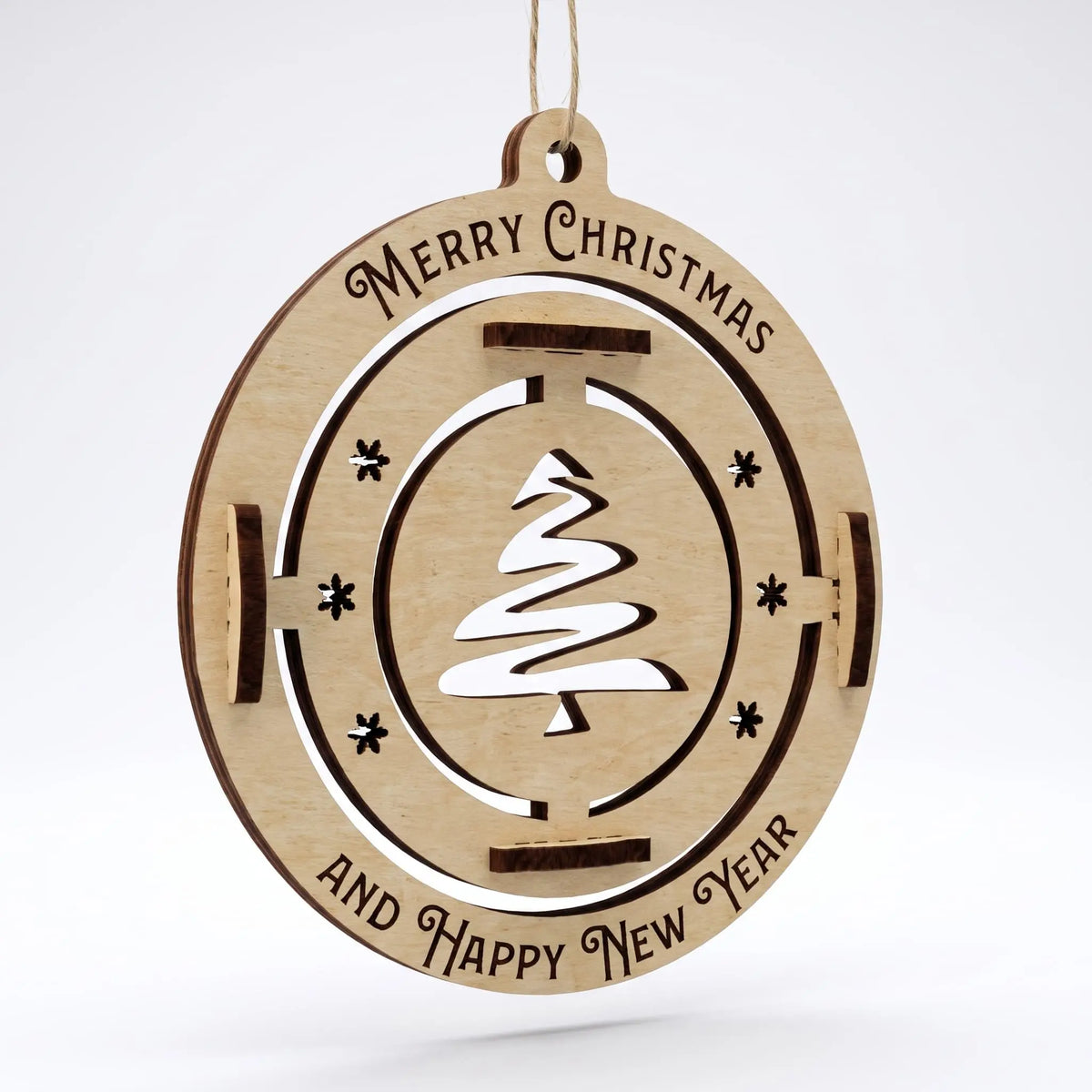 Front view of laser cut plywood bauble with fir tree cutout and engraved holiday greetings on plain white.
