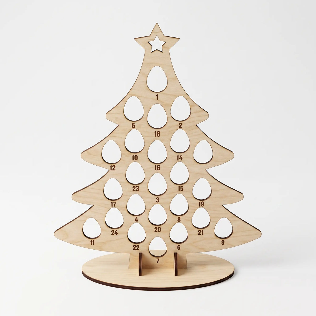 Front view of empty laser cut plywood tree shaped advent calendar stand with numbered egg holes on white.