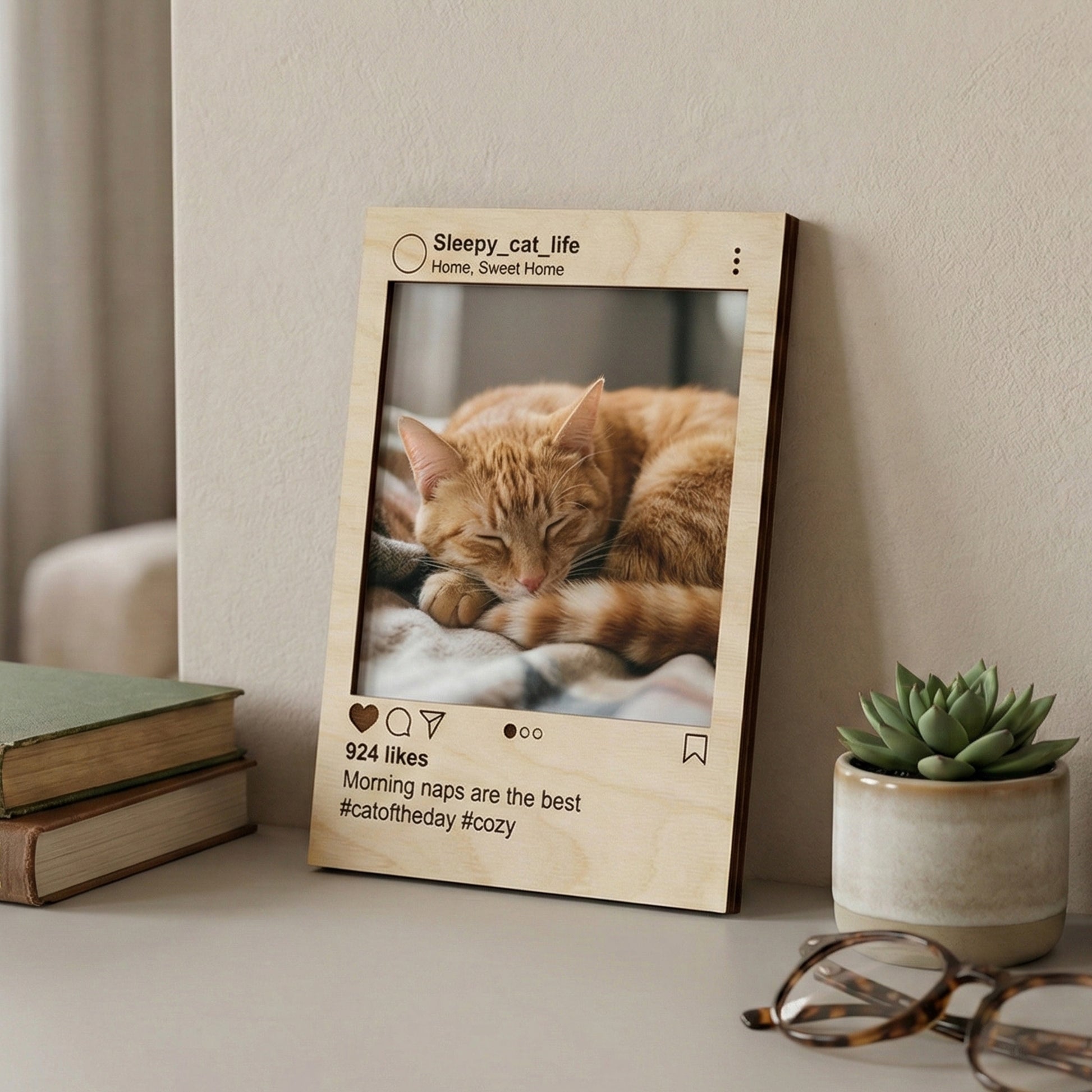 Laser cut wooden Instagram-inspired photo frame with engraved cat lover username and cozy caption, showcasing a relaxed feline portrait, on a bookshelf background.