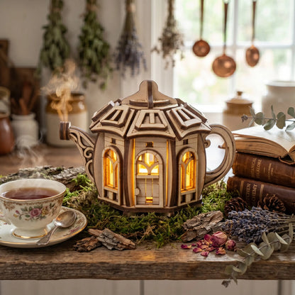 Decorative teapot-shaped lantern with a warm glow on a table with a cup of tea and books.