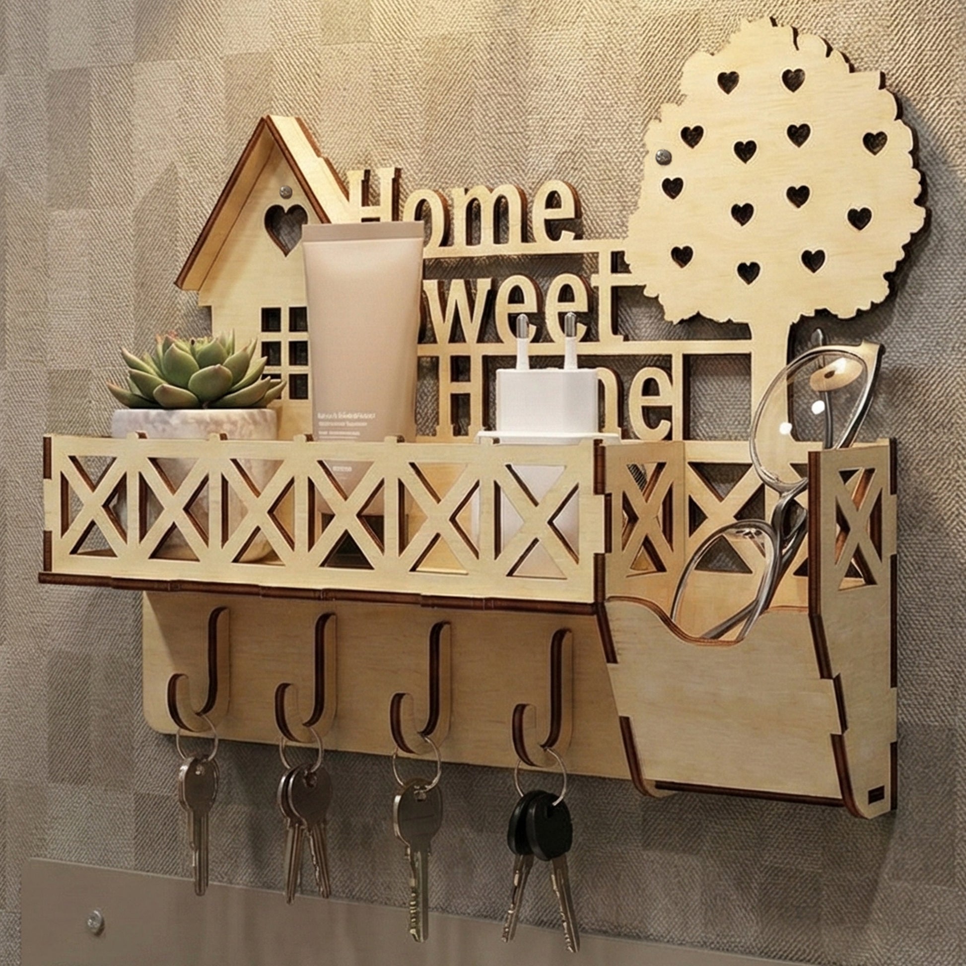 Wooden laser cut keyholder "Home Sweet Home" with a charming house silhouette, lattice balcony shelf for small items, multiple hooks for keys, and a heart-filled tree detail, mounted on a textured wall background.