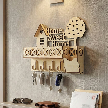 Elegant laser cut wooden keyholder "Home Sweet Home" design with a stylized house shape, open lattice shelf, curved hooks for keys, and a delicate heart-motif tree, shown on a soft herringbone-patterned wall background.