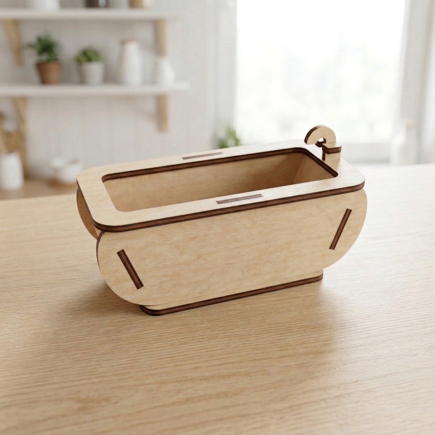 Miniature freestanding dollhouse bathtub made of smooth laser cut plywood. The tub features curved side panels with decorative slot details and a tiny wooden faucet at one end. Shown in a realistic scale on a wooden tabletop.