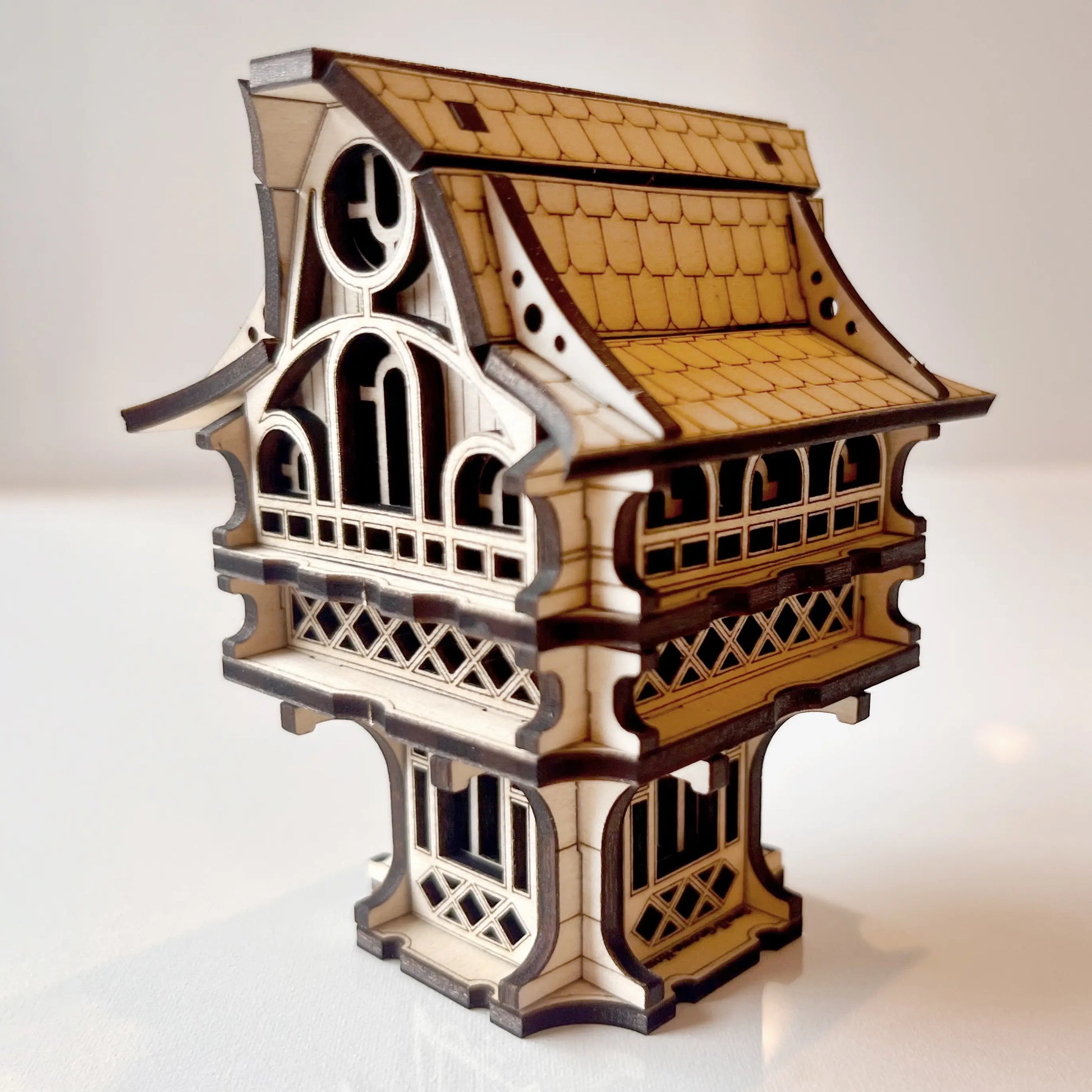 Miniature fantasy gnome house made of laser cut plywood. Detailed architectural structure with intricate arched windows and balconies.